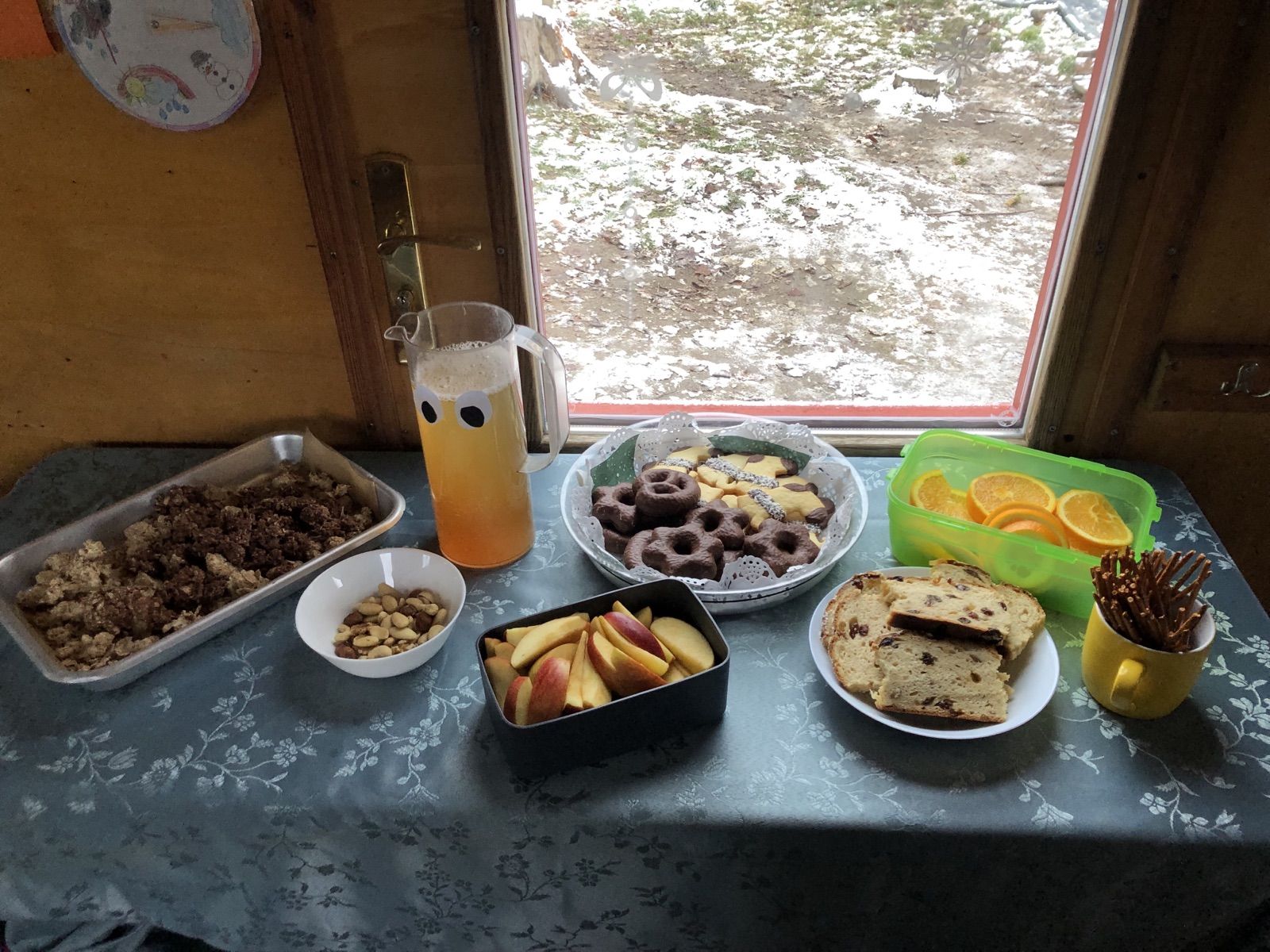 Gedeckter Brotzeittisch im Bauwagen mit Blick auf den ersten Schnee