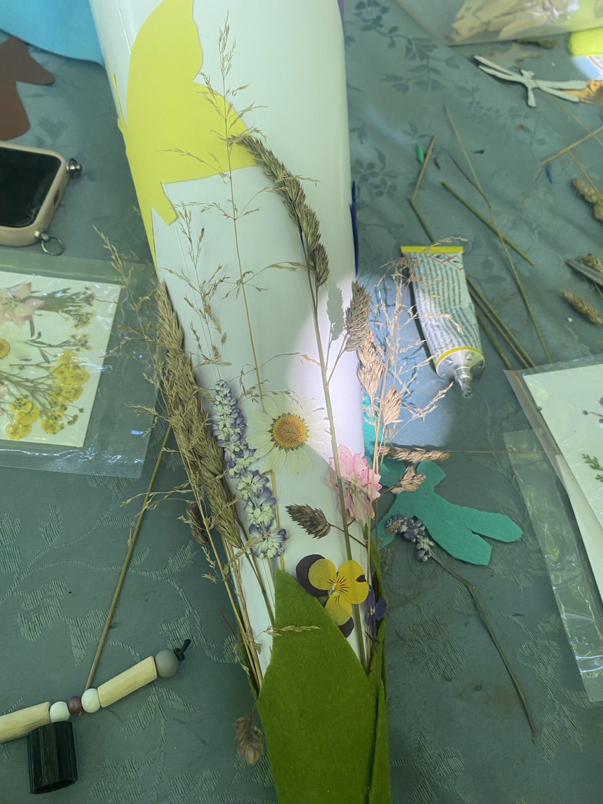 Schultüte, geschmückt mit gepressten Wiesenblumen und Gräsern