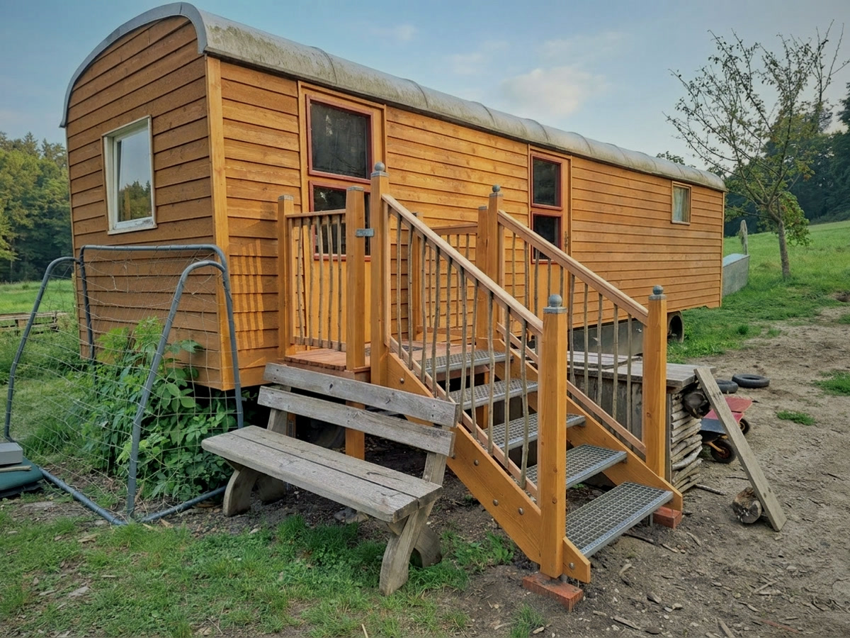 Der Bauwagen des Waldkindergartens mit Holztreppe am Waldrand